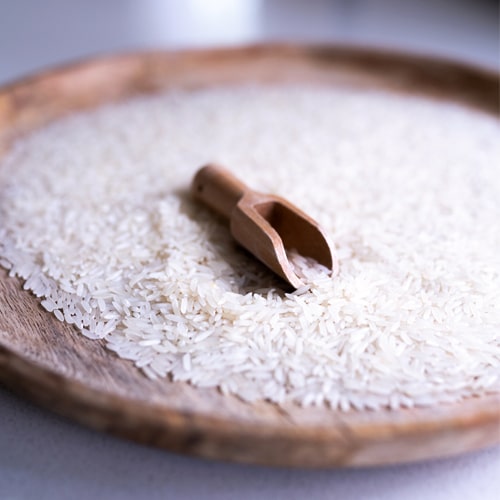 Riz basmati dans une assiette en bois pour illustrer la méthode cuisson du riz basmati